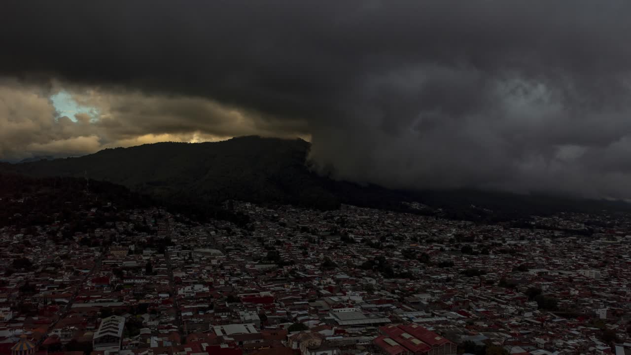 DRONE: DOLLY IN TIME-LAPSE OF A STORM ARRIVING AT URUAPAN, MICHOACÁN ON A CLOUDY DAY