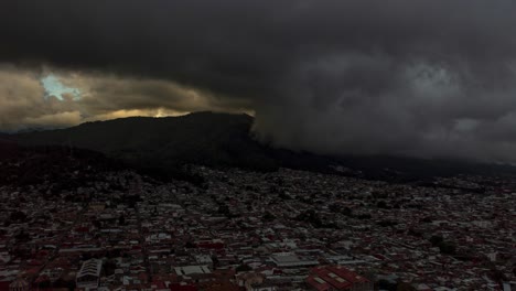 drone: dolly in time-lapse of a storm arriving at uruapan, michoacán on a cloudy day