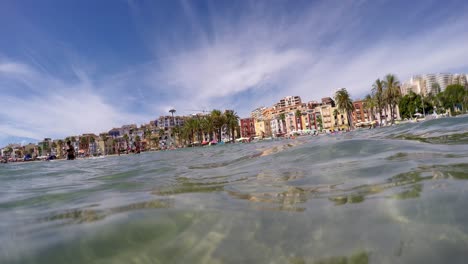 villajoyosa frente a la playa coloridas cabañas de pescadores, palmeras junto al paseo marítimo
