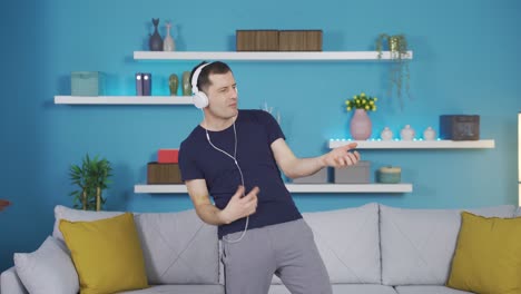 the fun guy is dancing alone at home listening to music.