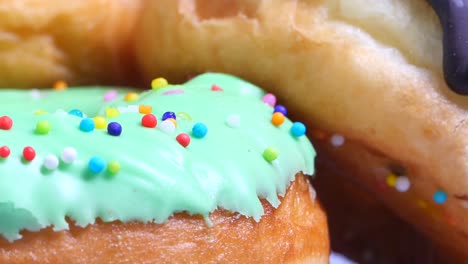 close up of green glazed donuts with sprinkles