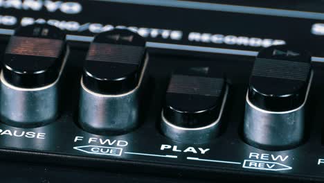 pushing play button on a vintage tape recorder