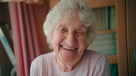 portrait of a happy elderly woman with full white hair looking at the camera and smiling with white teeth