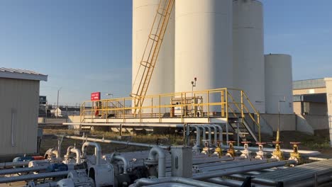 panning shot of fuel pipes and containers with metal ladders resting against