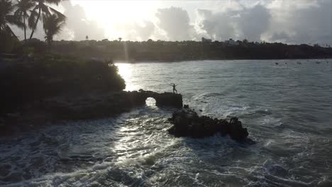 niña de pie sobre una roca en el borde del océano de brasil amor playa extraño túnel de roca