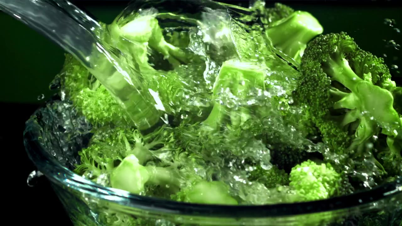 Cimette di broccoli fresche che vengono lavate con acqua al rallentatore
