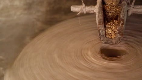 woman milling grain, to make flour