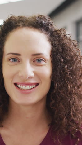 video of happy caucasian female teacher standing in school hall