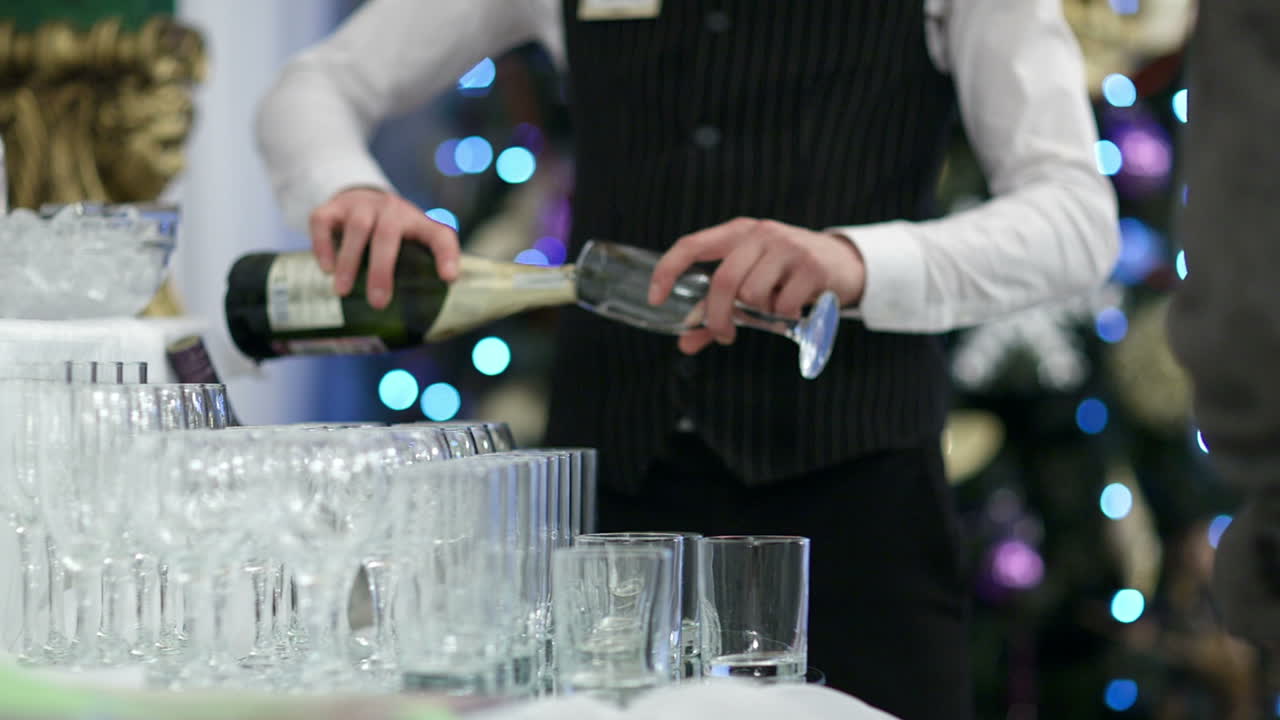 Waiter pouring glasses of champagne