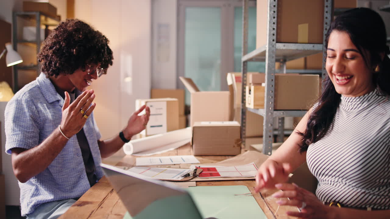 Jeunes partenaires commerciaux se donnant un high-five lors d'une collaboration au bureau