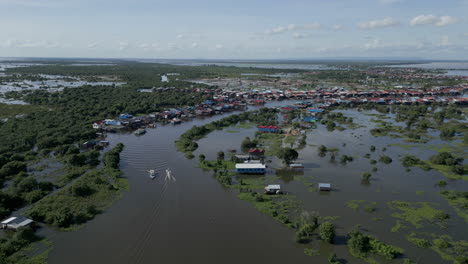 tonlé sap river bends through dense mangroves, opening to clusters of floating homes