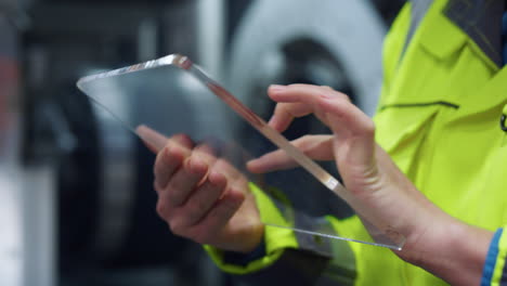 Supervisor-hands-typing-glass-tablet-computer-in-manufacturing-company-closeup