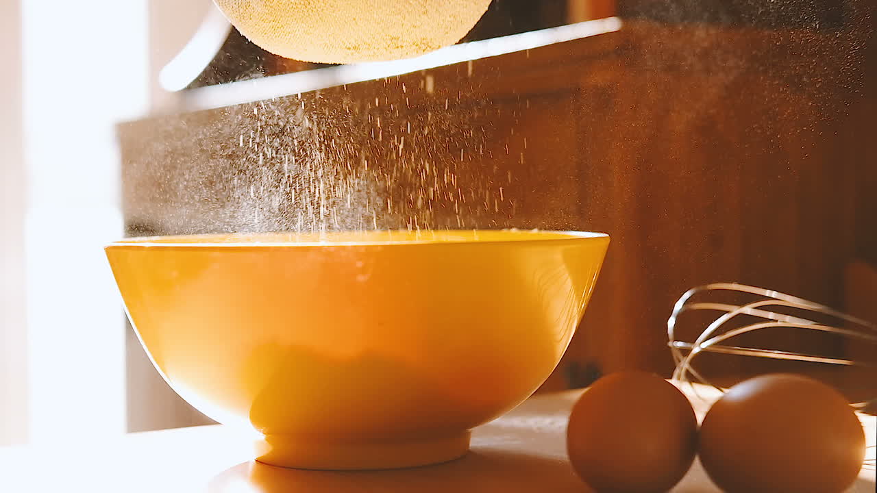 filtrando la harina en un cuenco amarillo, cámara lenta de cerca