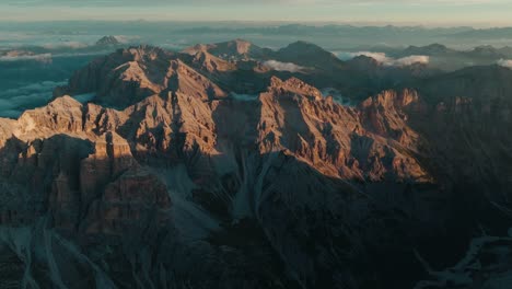 vista aérea lentamente inclinada de derecha a izquierda de los picos punta sud di fanes, punta nord y monte ciaval en las dolomitas de cortina d'ampezzo al amanecer