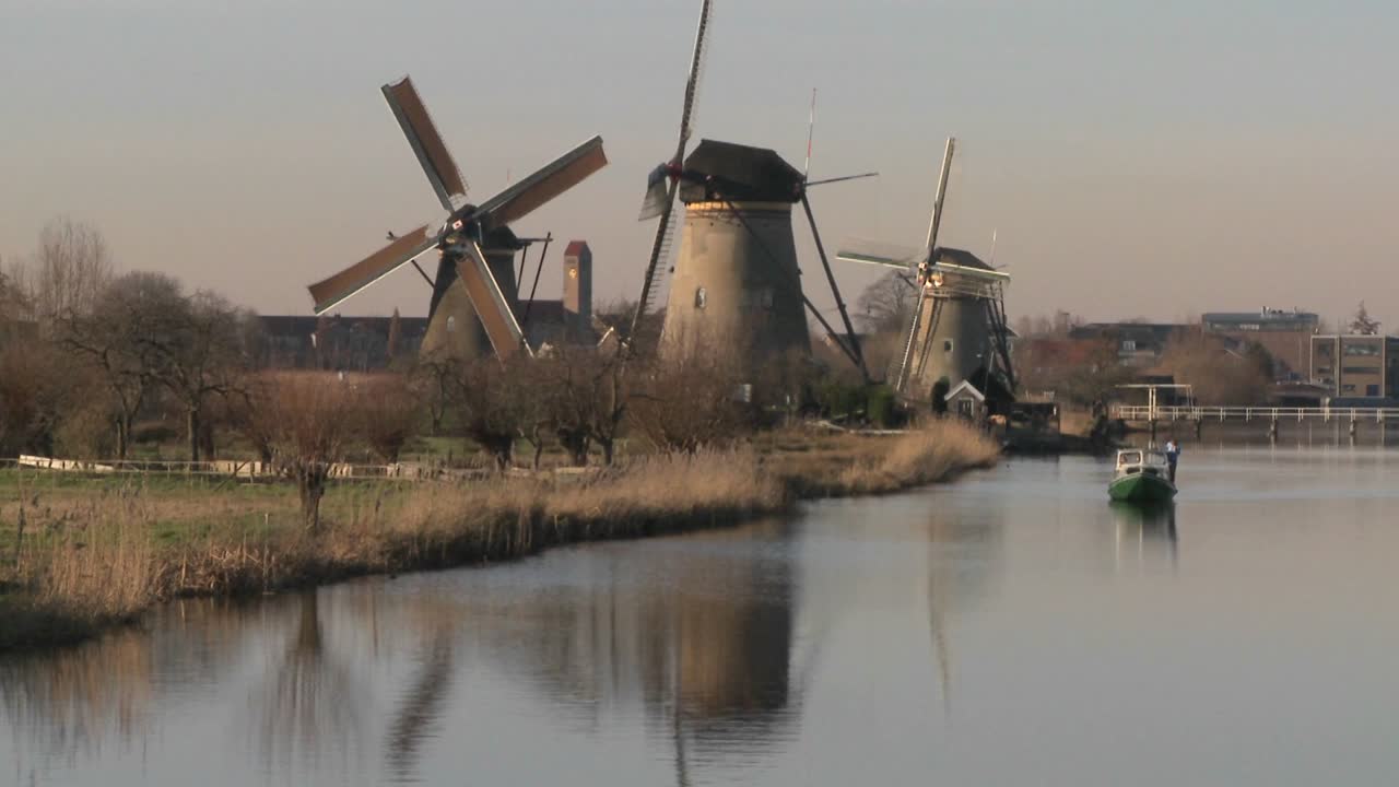 лодка движется по каналу в голландии с ветряными мельницами поблизости 1