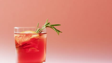 close up of drink with grapefruit on pink background