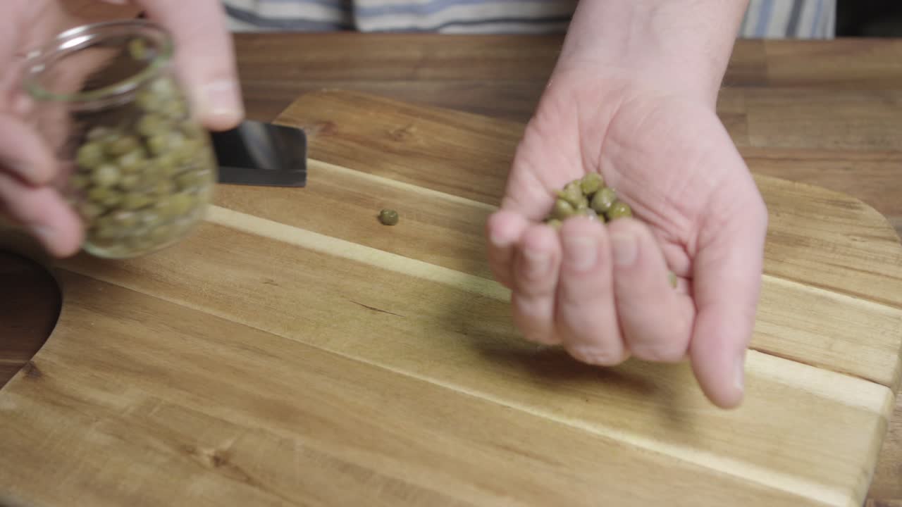 한 손 이 절단판 에 카퍼 를 놓는다