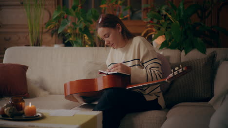 woman playing guitar writing song composing music