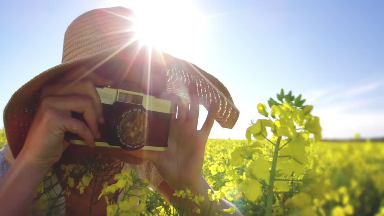 mujer tomando una foto de la cámara en el campo de mostaza