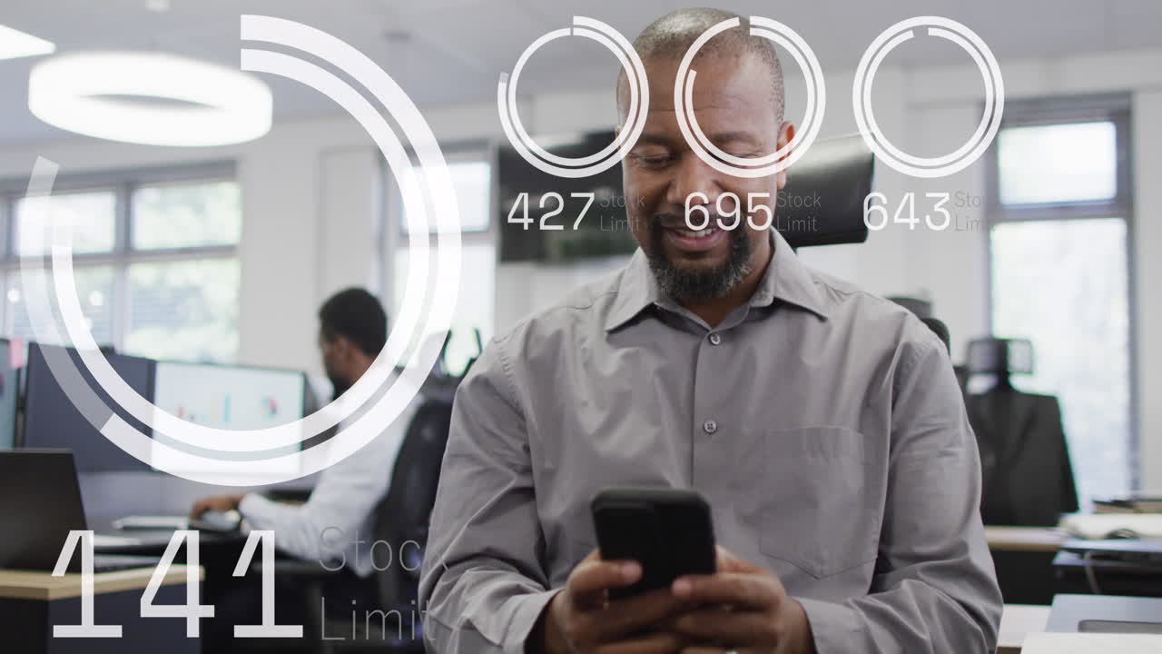 animación del procesamiento de datos sobre un hombre de negocios afroamericano usando un teléfono inteligente en la oficina.