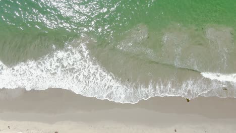 Vogelperspektive-Aus-Geringer-Höhe-über-Wellen,-Die-An-Einem-Hellen-Und-Sonnigen-Nachmittag-An-Einem-Sandstrand-Krachen