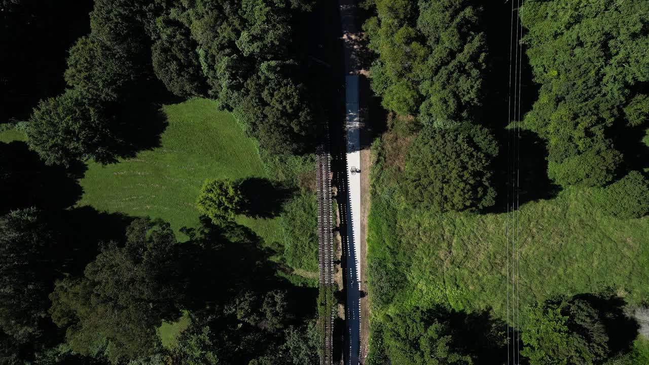 Aerial View of Cyclists on a Bike Trail Through a Forest