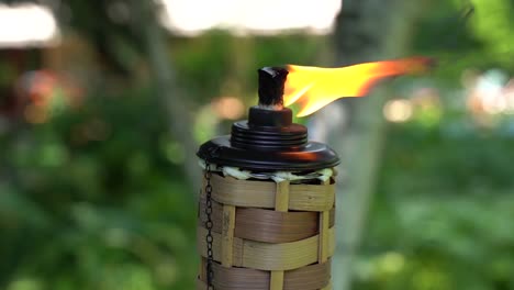 close up of hawaiian polynesian bamboo tiki torch burning at festive luau in slow motion