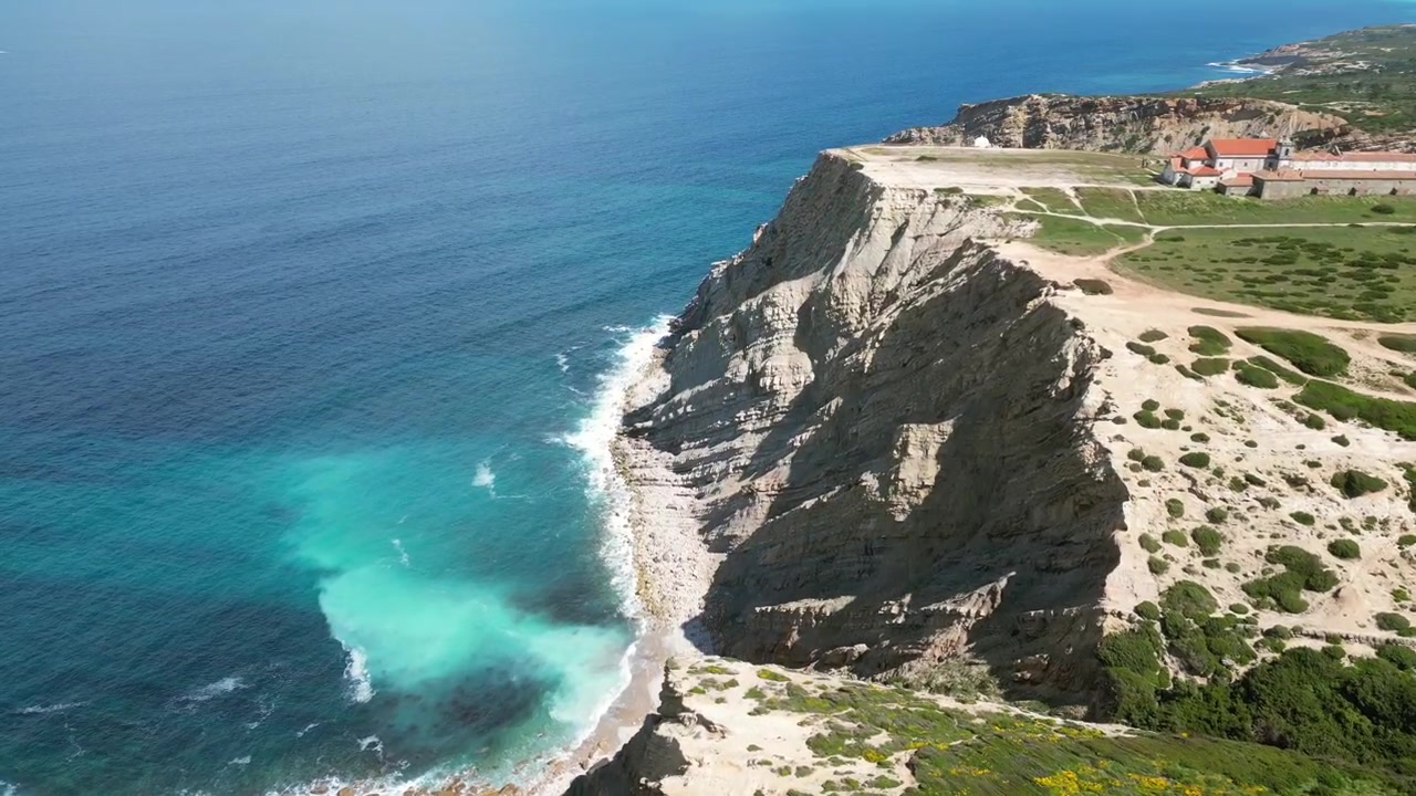 Riprese aeree con drone di Cabo Espichel, Portogallo: scogliere atlantiche spettacolari, costa frastagliata e vasto paesaggio oceanico sotto luce naturale. Ideale per progetti di viaggio e natura.