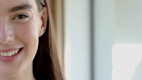 Close-up-of-a-teenage-Caucasian-girl-with-a-subtle-smile-and-brown-hair,-with-copy-space,-at-home