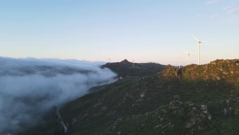 Turbinas-Eólicas-Girando-En-La-Montaña-Al-Amanecer-Y-Nubes-En-El-Valle,-Caramulo-En-Portugal