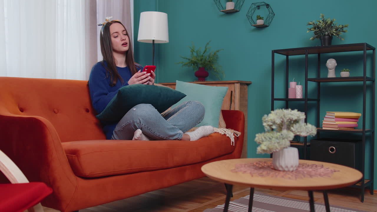 슬픈 젊은 여성은 휴대 전화 브라우징을 사용하고, 놀랐을 때 갑작스러운 나쁜 복권 결과를 잃습니다.