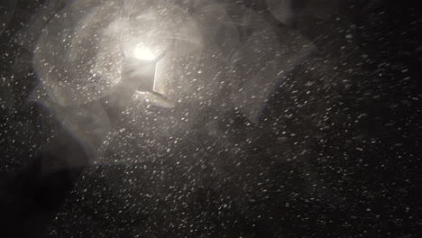 heavy snow falling in slow motion under a street light