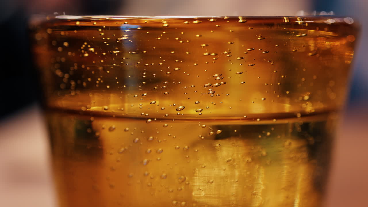 Close up of sparkling water in a yellow glass on a table at a restaurant