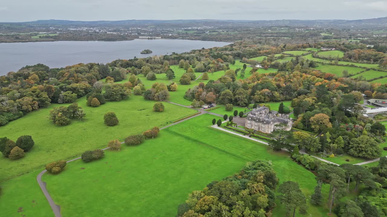 Aerial view of Muckross House, Ireland, amidst lush greenery and lakeside
