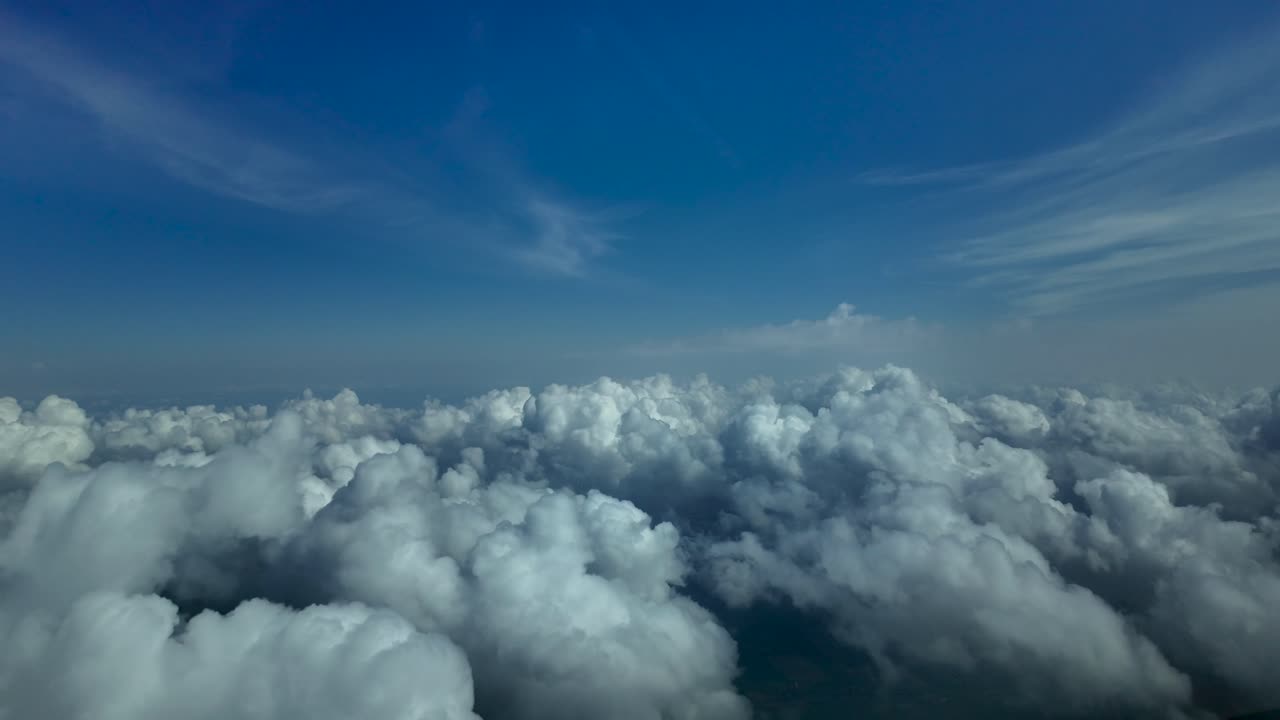 piloto pov volando en un cielo azul profundo sobre algunas nubes de cúmulo blanco esponjoso