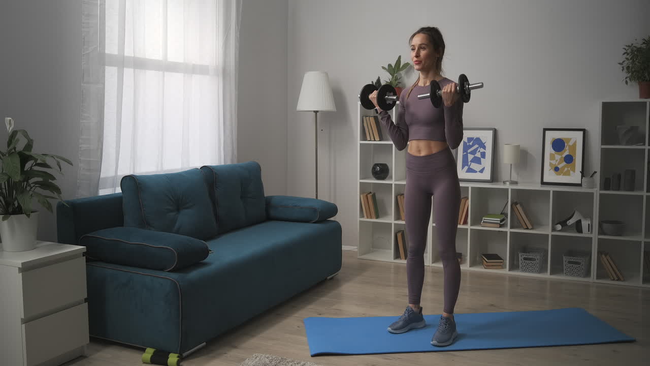 entrenamiento en casa con pesas para una buena forma del cuerpo mujer deportiva está entrenando apartamento fitness y bienestar estilo de vida saludable