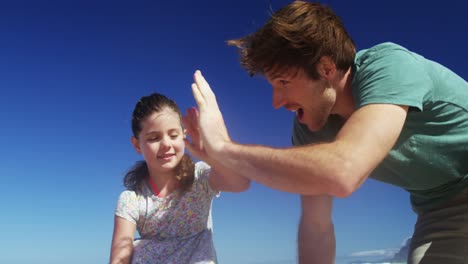 Glückliche-Familie,-Die-Sich-Am-Strand-Gegenseitig-High-Five-Gibt