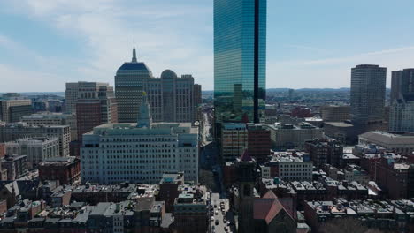 Modern-John-Hancock-Tower-and-iconic-large-buildings-on-Boylston-street.-Backwards-reveal-of-churches-in-residential-development.-Boston,-USA