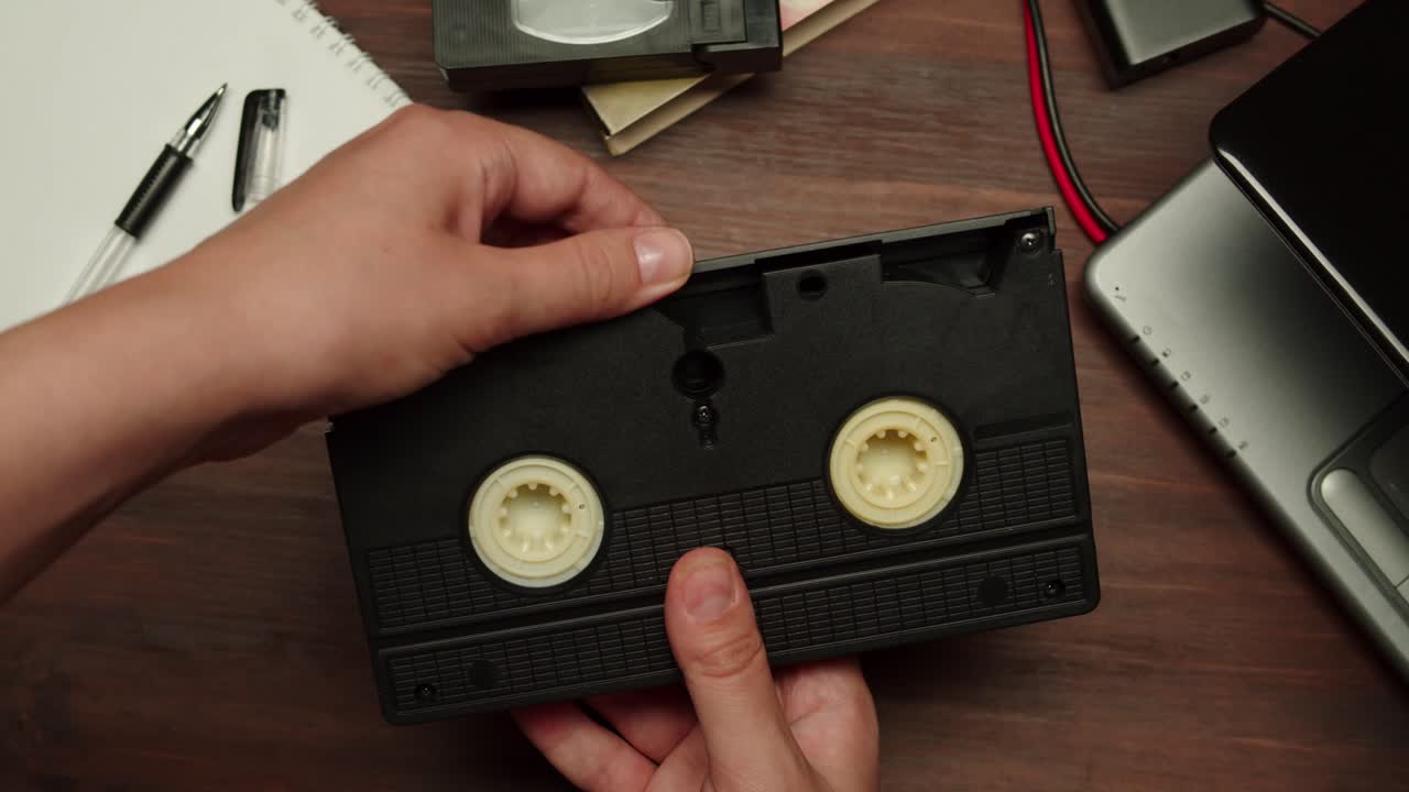 Close Up of Hands Opening a VHS Video Cassette