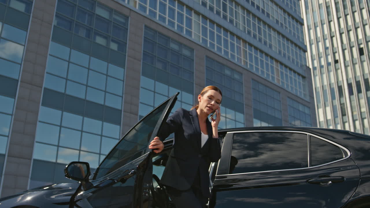 mujer conductor dejando automóvil llamando. elegante mujer jefe hablando teléfono inteligente
