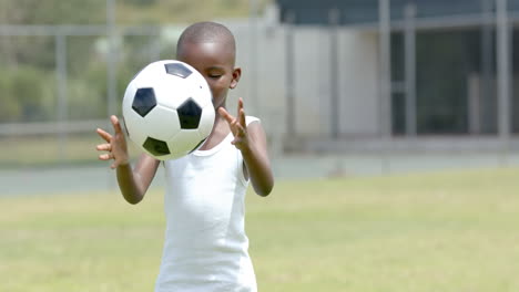 a young african american boy holding soccer ball