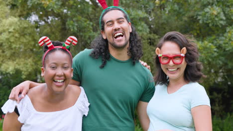 at christmas, young diverse friends wearing festive headbands laughing outdoors in holiday spirit