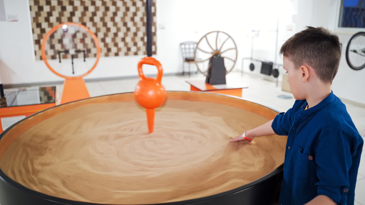 schoolboy makes practical experiments at a science centre. Science museum