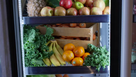 Nahaufnahme-Eines-Nahen-Kühlschranks,-Der-Mit-Grünem-Gemüse-Und-Verschiedenen-Obstsorten-Gefüllt-Ist