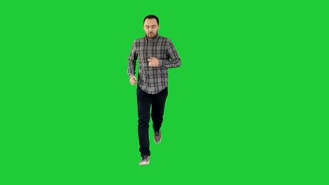 young man running excited on a green screen, chroma key