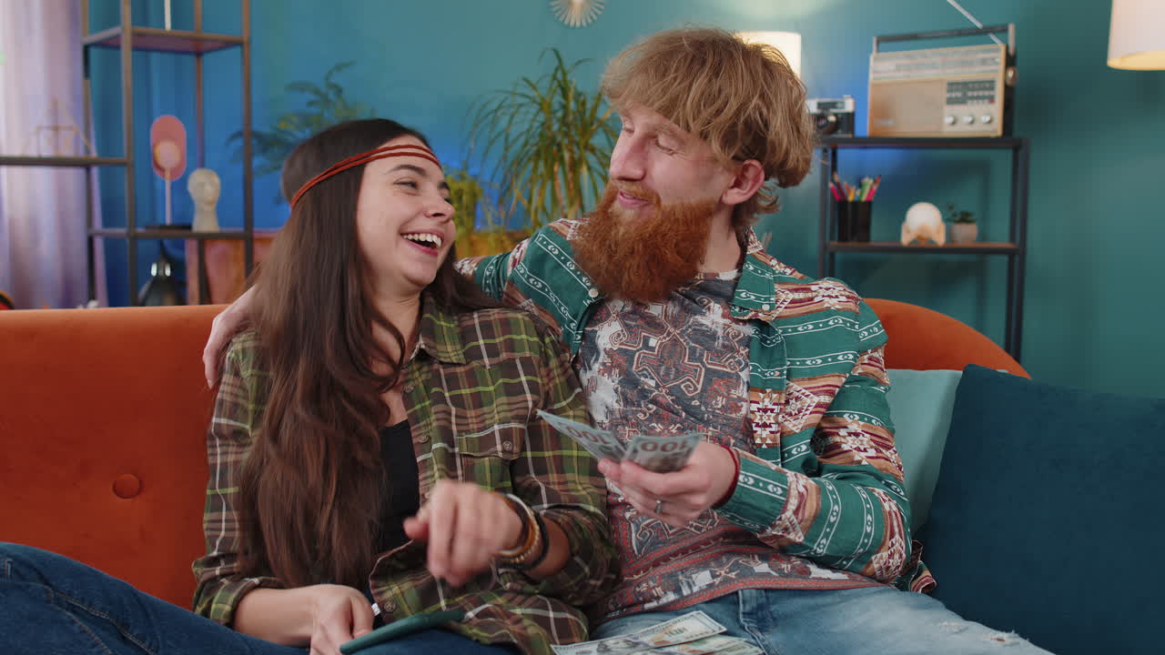 Smiling happy family couple man woman counting money cash use smartphone income saves lottery win