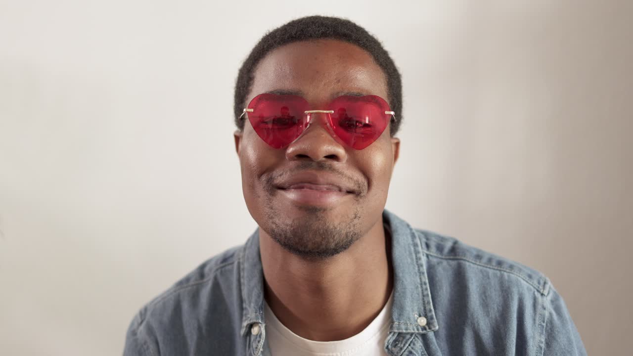 Young Black Man Wearing Red Heart-Shaped Sunglasses Smiling