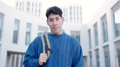 cheerful young man with backpack at college campus
