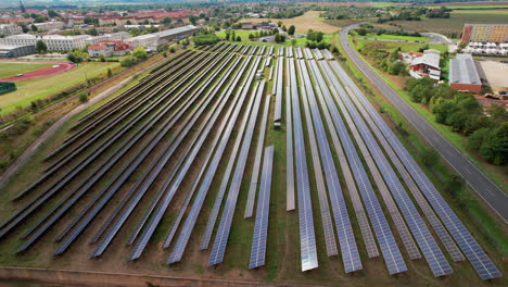 Vista-Aérea-Panorámica-De-La-Instalación-De-Paneles-Solares-Alrededor-De-Una-Ciudad-En-Alemán.