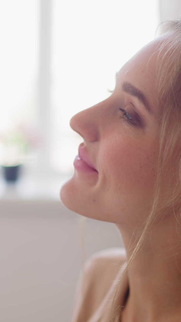 Young blonde woman with ponytail enjoys cup of hot drink relaxing in light comfortable office room after hard day of work closeup slow motion